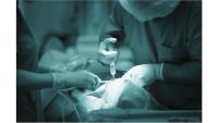Draped patient receiving injection from a clinician as another assists